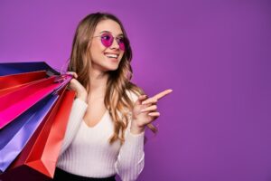 20230827214005_[fpdl.in]_beautiful-smiling-young-blonde-woman-pointing-sunglasses-holding-shopping-bags-credit-card-pink-wall_496169-1506_normal